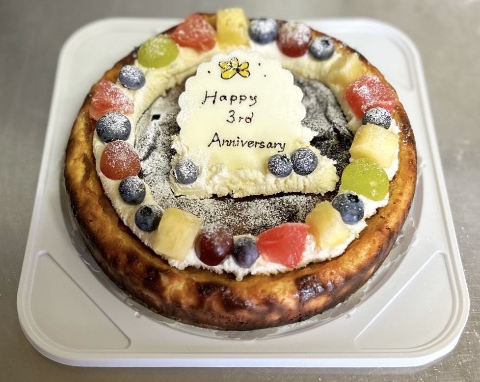 3周年のメッセージプレートとフルーツを飾ったチーズケーキ