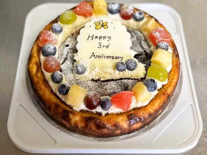 3周年のメッセージプレートとフルーツを飾ったチーズケーキ