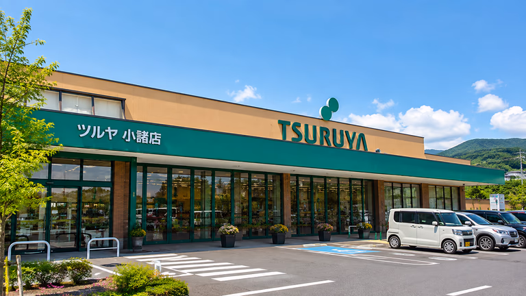 青空の下に立つツルヤ小諸店の外観